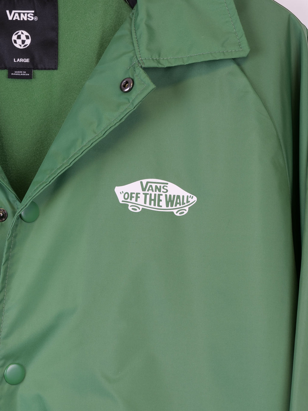 Giacca da uomo Vans verde in tessuto sintetico, modello Off The Wall Coach Jacket, con logo stampato sul petto e chiusura a bottoni.