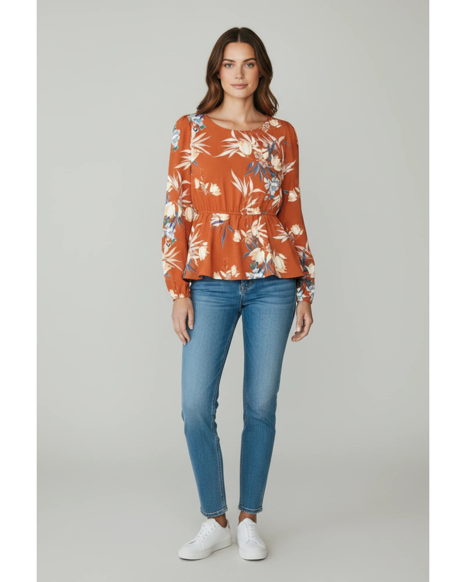 Modella indossa maglia ULTIMATAGLIA.COM arancio bruciato con stampa floreale, maniche lunghe e vita peplum elasticizzata
