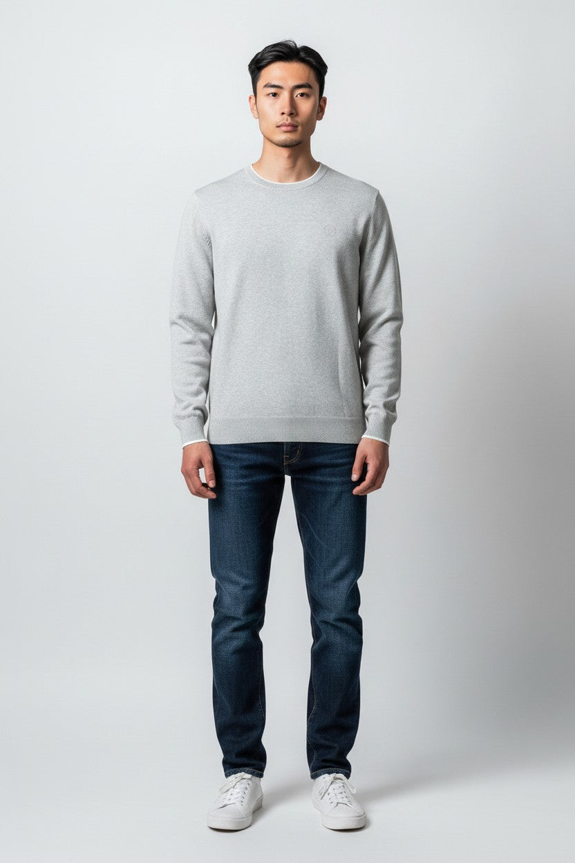 Modello indossa maglia girocollo grigia in cotone biologico ULTIMATAGLIA.COM con logo ricamato e maniche lunghe