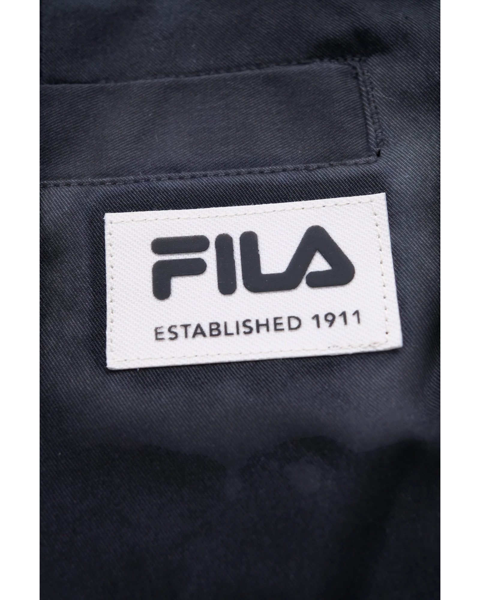 Pantaloni Fila TAIZHOU blu in tessuto tecnico con tasche e cordoncino in vita. Logo Fila Established 1911.