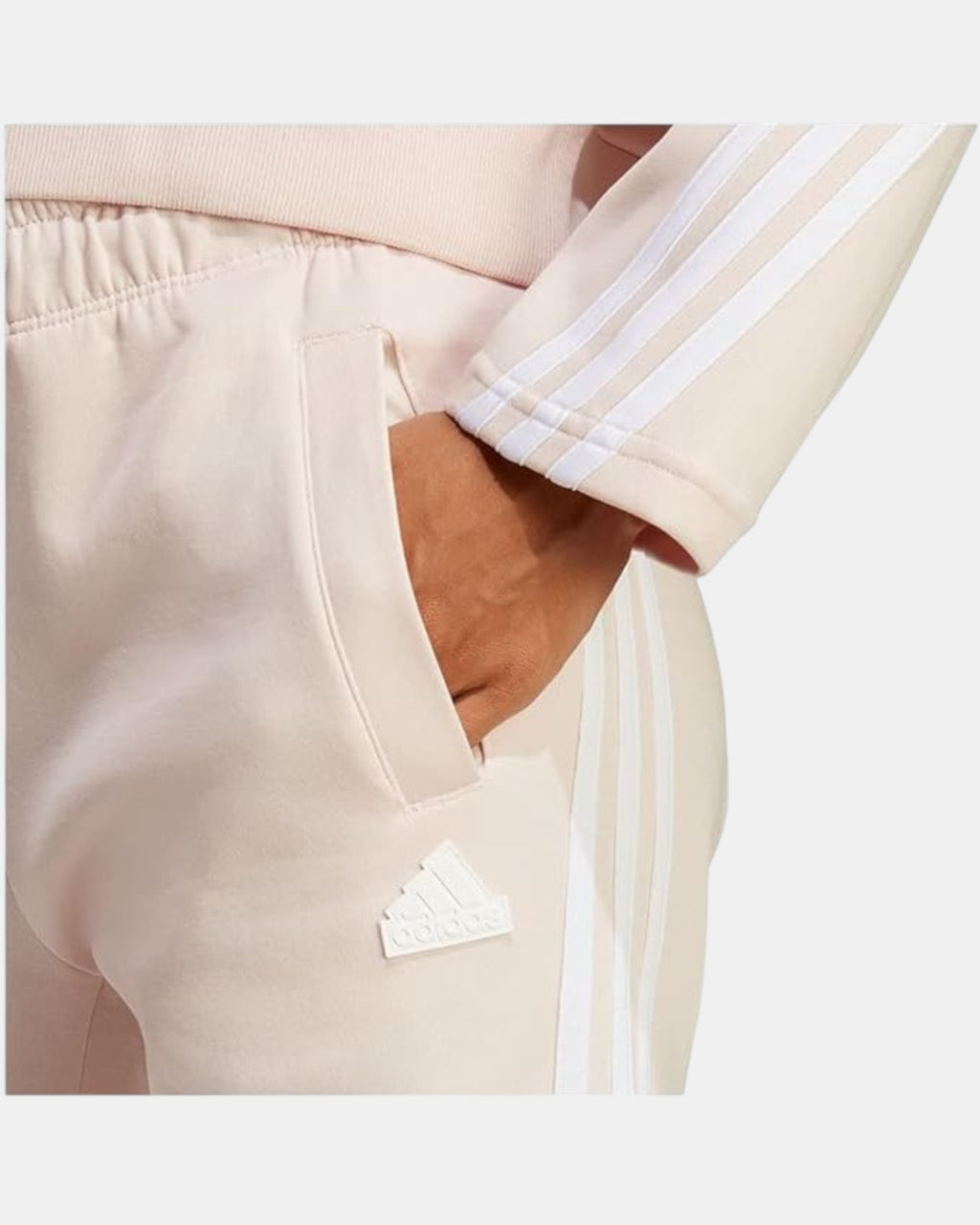 ULTIMATAGLIA.COM Pantaloni Adidas beige in fleece con iconiche tre strisce bianche laterali e logo in rilievo.
