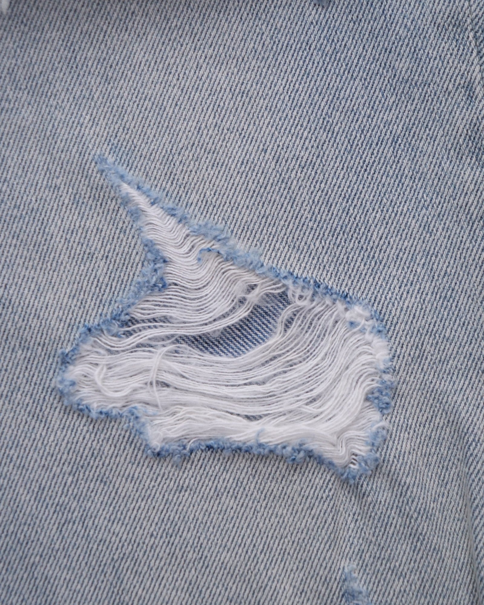 ULTIMATAGLIA.COM light wash denim boyfriend shorts with distressed details and frayed hem.